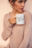 Coffee mug mockup held by a woman wearing a cozy sweater 22441